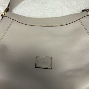 Ladies, Dooney and Bourke purse new in great condition has one small spot Firm